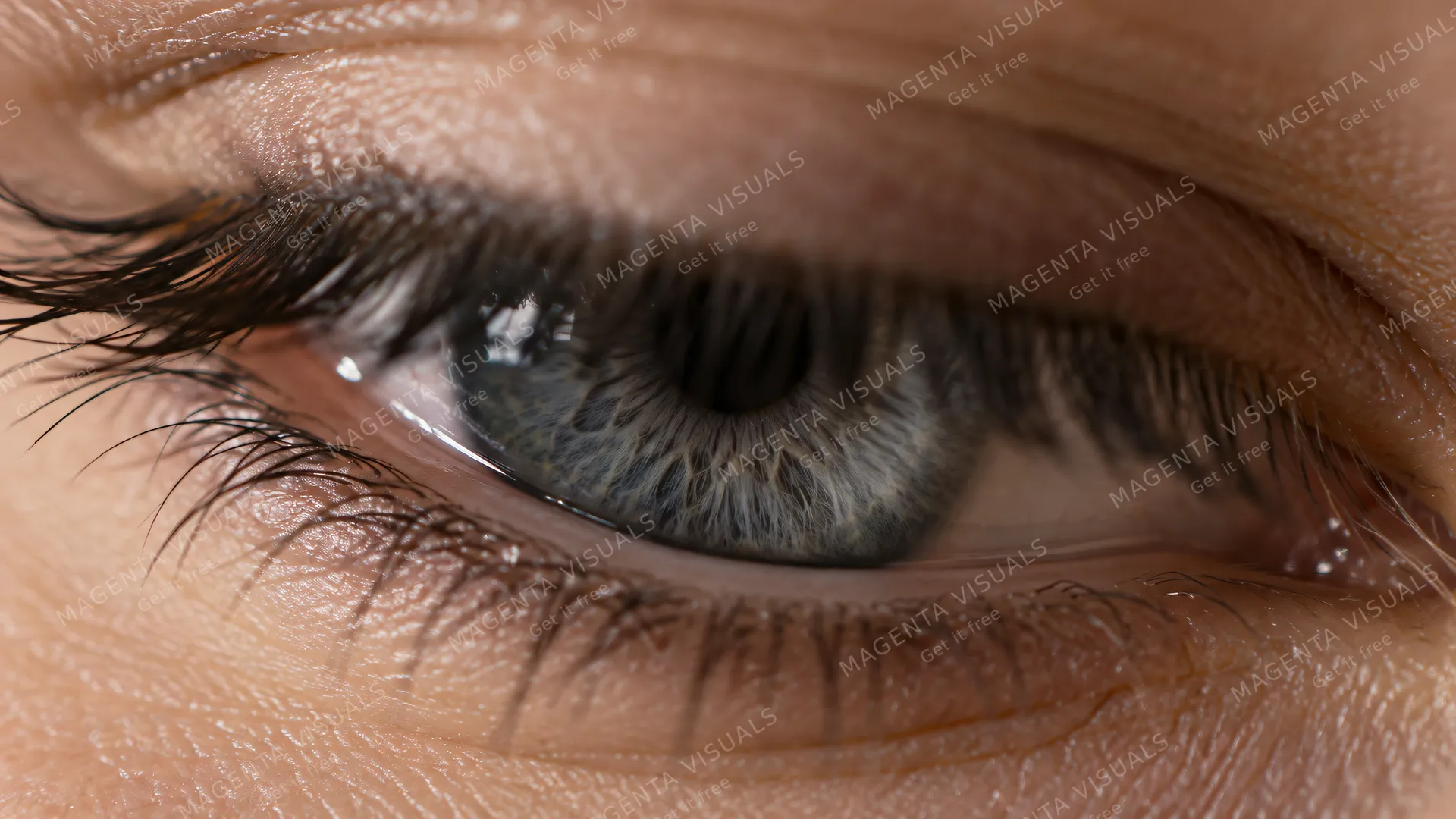 4K An extreme close-up photorealistic shot of a human eye in 16:9 widescreen, featuring a beautiful smoky slate-grey iris captured in a subtle mid-blink moment.