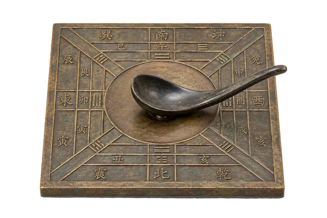 4K transparent cutout of product photography of a single ancient Chinese lodestone compass, a smooth carved magnetic spoon resting on a square bronze diviner's board with engraved directional markings, is…