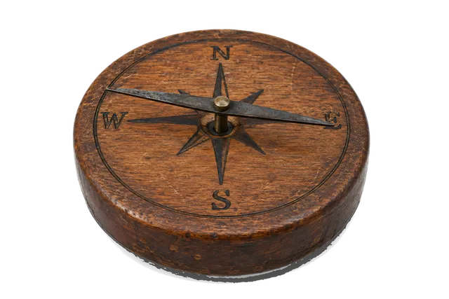 4K transparent cutout of product photography of a single simple ancient magnetic needle compass featuring an iron needle resting on a central pivot point above a simple wooden base with cardinal direction…