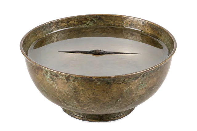 4K transparent cutout of product photography of a single ancient water-bowl compass consisting of a simple bronze bowl filled with clear water holding a floating magnetized iron needle, isolated object, e…