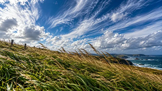 4K 16:9 widescreen desktop wallpaper of a full-bleed photoreal photograph capturing a dynamic sky moment with high winds.