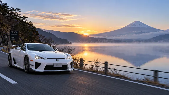4K wallpaper of A photorealistic 16:9 widescreen automotive photography shot of a pristine pearl white Lexus LFA cruising along an empty lakeside bypass road on the left side of the frame in clea…