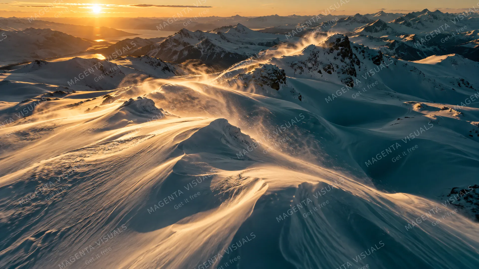 4K 16:9 aerial establishing cinematic drone shot skimming across endless wind-sculpted mountain snowdrifts at golden hour, low-raking sunlight catching crystalline dust plumes, deep…