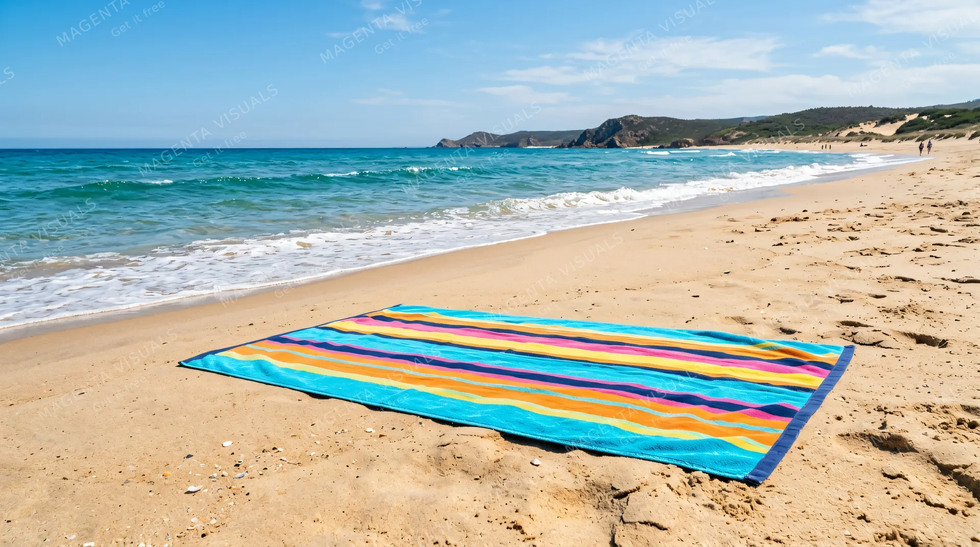 4K 16:9 photoreal photograph of a colorful striped beach towel spread out evenly on dry warm sand near the water's edge at a pristine beach.